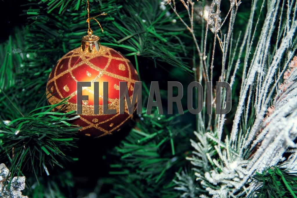 A red Christmas tree ornament decorated with golden glitter