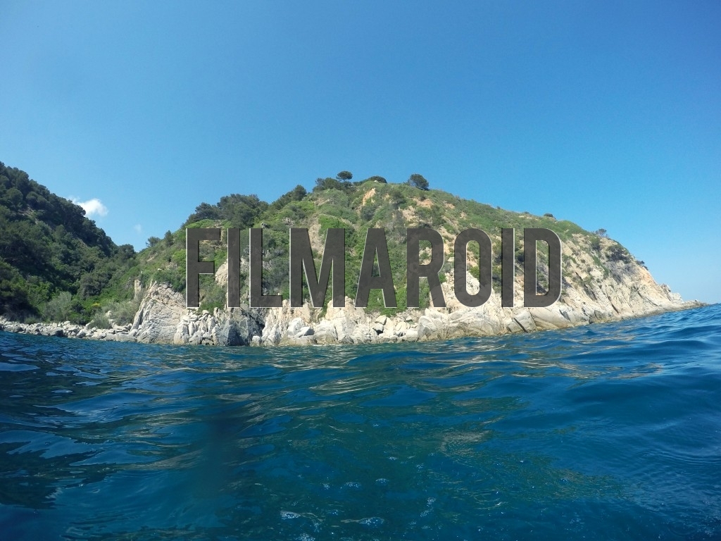 A rocky island seen from the water while taking a swim during a bright summer day