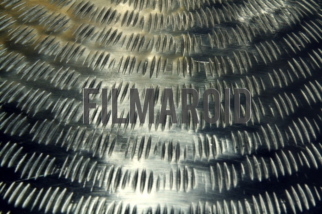 Closeup of a carved old steel table top with lots of scratches and details in texture