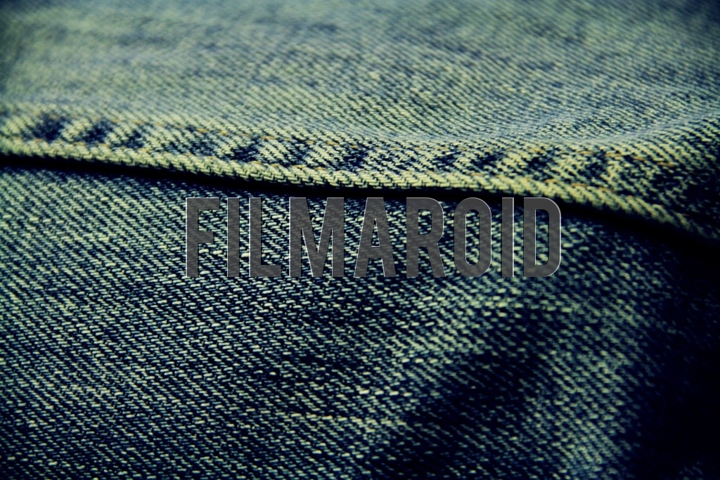 Old blue denim texture Old blue denim texture - Closeup of an old blue denim fabric with sewing yellow stitches
