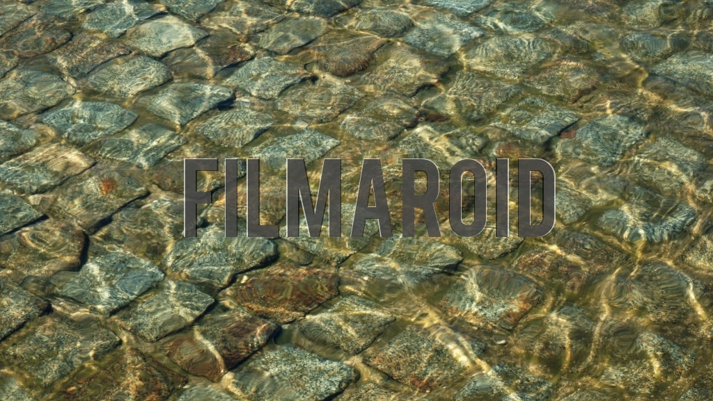 Texture view of water ripples over multicolored squared stones used in the bed of a European fountain