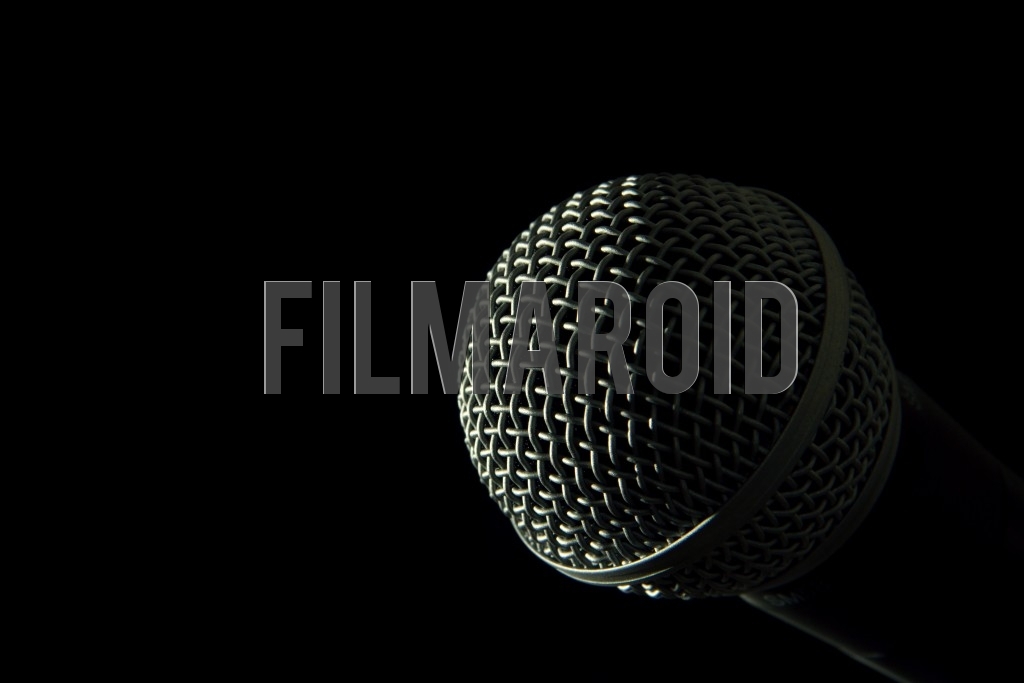 Voice microphone head isolated against black Voice microphone head isolated against black - Detail view of the head of a voice microphone isolated against a pitch black background