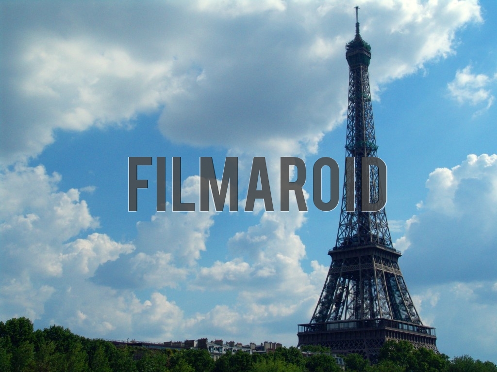 Eiffel Tower with cloudy sky during a warm summer Parisian day Eiffel Tower with cloudy sky during a warm summer Parisian day - The Eiffel Tower taking over the Parisian landscape during one sunny summer day