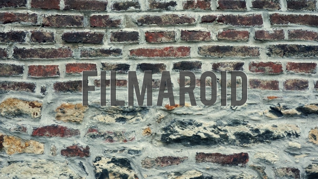 Detail view of an old brick wall with irregular sizes and matched up to colorful stones on bottom