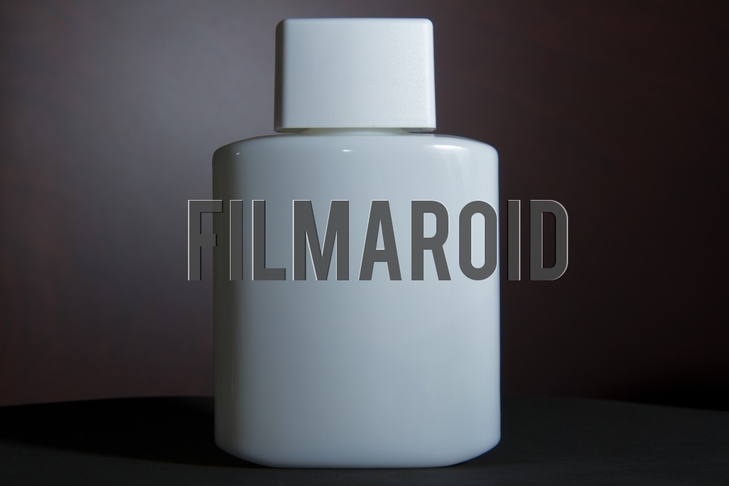 Beautiful and stylish vintage white lotion bottle isolated against a wooden background