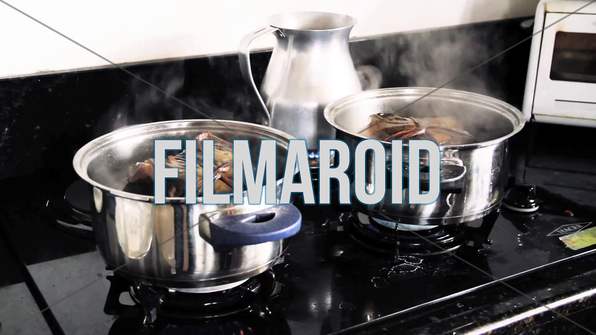 Colombian food - A couple of Colombian tamales cooking in kitchen pot with boiling water and lots of steam visible